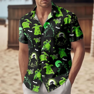 May include: Black short-sleeved shirt featuring a repeating pattern of green cartoon characters, bats, and the text "Boogie Woogie". The shirt has a camp collar and is worn by a person.