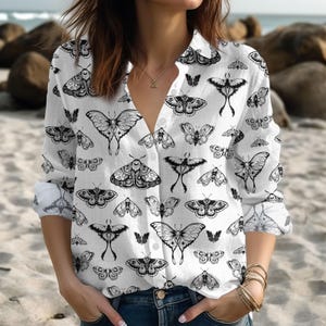 Peut inclure: Chemise boutonnée blanche à manches longues avec un imprimé de papillons noir et blanc. La chemise a un col en V et une coupe ample.