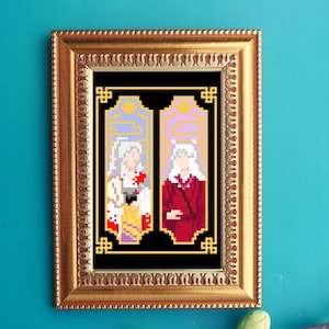 Puede incluir: Una impresión en pixel art enmarcada que presenta dos figuras con cabello blanco y ropa colorida. La obra de arte está sobre un fondo negro y enmarcada en un marco dorado ornamentado. La impresión se muestra en una pared turquesa.