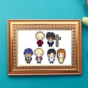 May include: A framed cross-stitch artwork featuring pixelated anime-style characters in various outfits. The characters have different hair colors and clothing. The frame is gold-colored and the background is a teal color.