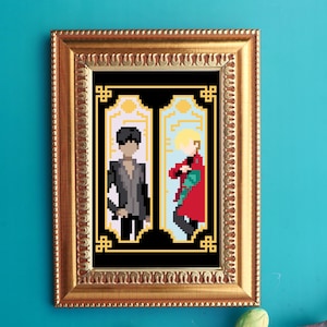 May include: A framed pixel art print featuring two figures in a gold frame. One figure is in a gray suit, the other in a red coat. The background is black with light blue and yellow accents. The frame is gold.