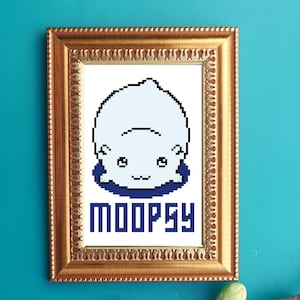 Può includere: Una stampa incorniciata di un orso polare bianco pixelato con occhi blu, seduto su uno sfondo blu. Il testo "MOOPSY" è scritto in blu sotto l'orso.