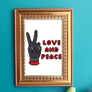 May include: A framed print with a gold-colored ornate frame. The artwork features a pixelated black hand making a peace sign, with the words "LOVE AND PEACE" in red block letters. The background is white.