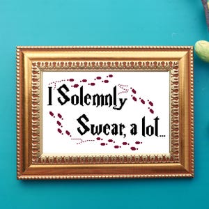 May include: A framed white cross-stitch with the text "I Solemnly Swear, a lot..." in black font. The text is surrounded by a trail of red footprints.