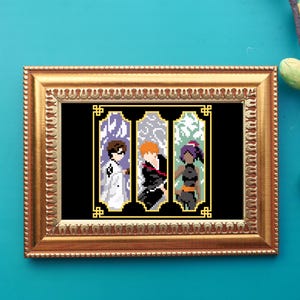 May include: A framed pixel art piece featuring three anime characters. The artwork is set against a black background and framed in a gold-colored ornate frame. The characters are depicted in a pixelated style with distinct color palettes and designs.