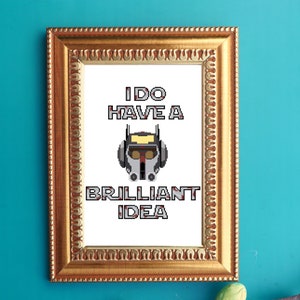 May include: A white framed print with the text "I DO HAVE A BRILLIANT IDEA" in black and red. A pixelated image of a helmet with a yellow visor is centered above the text.
