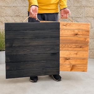 May include: Two rectangular wooden boards constructed from horizontal planks, each featuring a rope handle at the top. One board is finished in a dark black stain, while the other board displays a natural light brown wood grain finish.