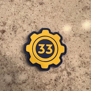 May include: A yellow and blue gear-shaped patch with the number 33 in the center.