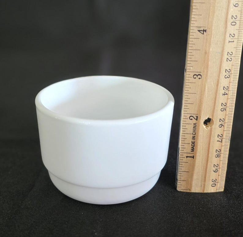 May include: A white ceramic planter with a double rim. The planter is approximately 2.5 inches tall and 3 inches in diameter.