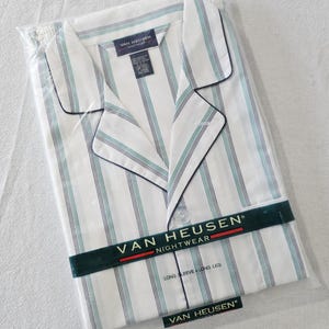 May include: White pajama set with vertical stripes in teal and navy blue, packaged in clear plastic. The set includes a collared shirt with black trim and long sleeves. The brand name "VAN HEUSEN NIGHTWEAR" is printed on the packaging.