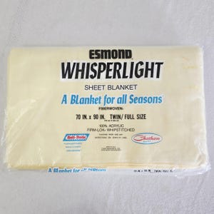 May include: A packaged Whisperlight sheet blanket, fiberwoven, in a light yellow color. The package reads "A Blanket for all Seasons" and is 70 in. x 90 in. for a twin/full size bed. The blanket is 100% acrylic and firm-lok whipstitched.