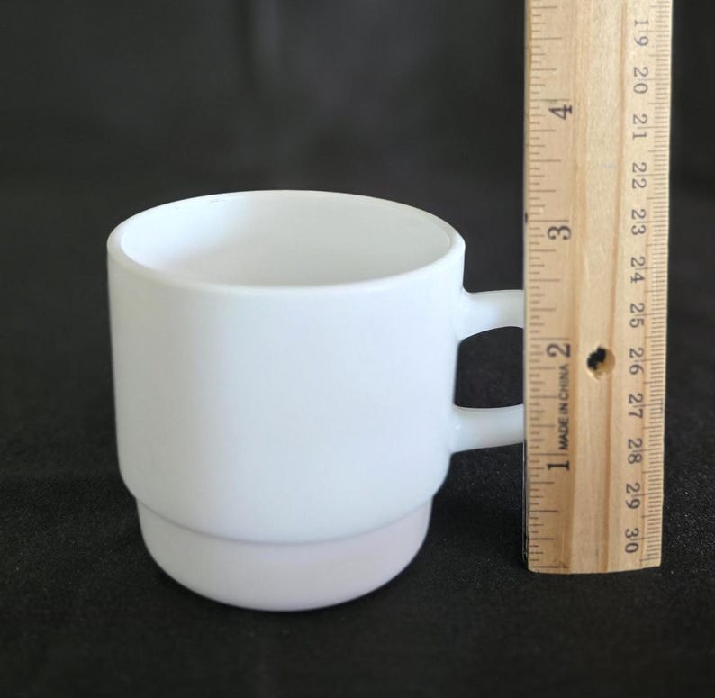 May include: A white ceramic mug with two handles. The mug is stacked in two sections and is approximately 3 inches tall.