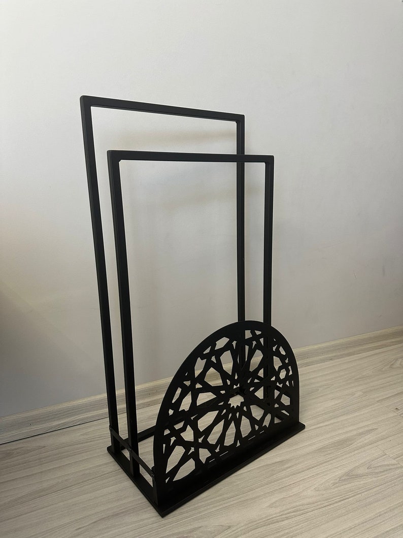 May include: Black metal stand with two rectangular shelves and a decorative, geometric, half-circle base.