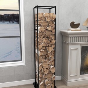 May include: A black metal log rack with stacked firewood inside. The rack is standing on a wooden floor in front of a fireplace.