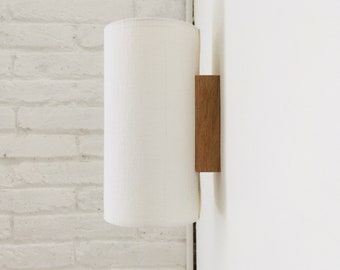 Wall light made of oak wood and white linen fabric. Wall light for japandi style home lighting and decoration.
