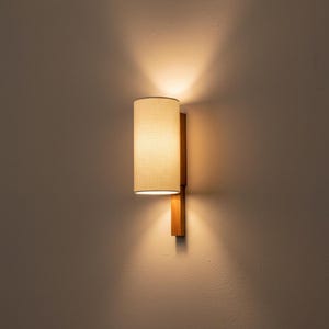 Moderne, cilindrische wandlamp, handgemaakt van eikenhout en natuurlijk linnen.
