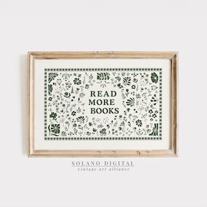 Puede incluir: Una impresión enmarcada con las palabras "READ MORE BOOKS" en verde oscuro, rodeada por un borde de ilustraciones florales y botánicas. La impresión tiene un fondo color crema y está enmarcada en un marco de madera marrón claro. La parte inferior de la impresión tiene el texto "SOLANO DIGITAL vintage art alliance".
