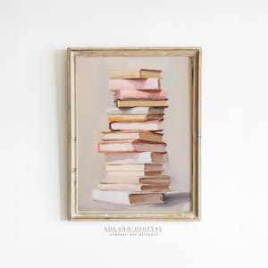 Puede incluir: Una pintura enmarcada de una pila de libros en varios tonos de beige, rosa y rojo. Los libros están dispuestos en una torre, con el libro más grande en la parte inferior y el libro más pequeño en la parte superior. La pintura está sobre un fondo blanco.