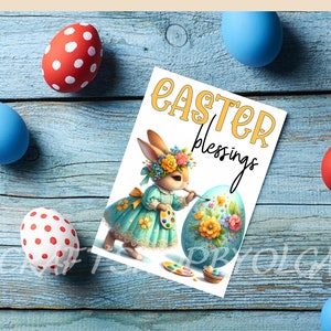 May include: A white card with the text "Easter Blessings" in yellow letters. A cartoon bunny wearing a blue dress with floral accents is painting a large Easter egg with flowers.