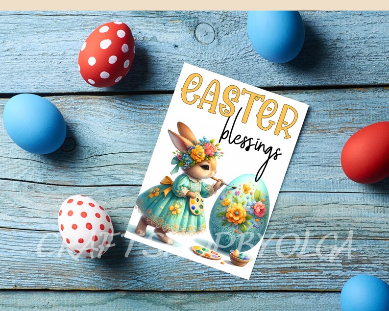 May include: A white card with the text "Easter Blessings" in yellow letters. A cartoon bunny wearing a blue dress with floral accents is painting a large Easter egg with flowers.