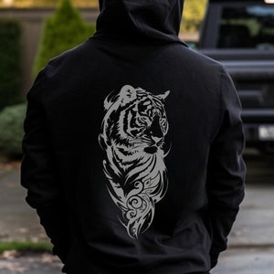 May include: A black hoodie with a gray tiger graphic on the back. The tiger is facing to the left and has a floral design around it. The hoodie is ash gray.