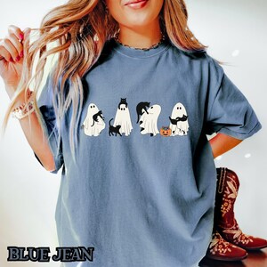 K&ouml;nnte beinhalten: Ein blaues T-Shirt mit einem Aufdruck von f&uuml;nf Geistern, die schwarze Katzen halten. Die Geister tragen einen K&uuml;rbis und einige halten eine Katze in ihren Armen.