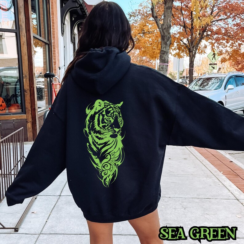 May include: Black hoodie with a green tiger graphic on the back. The text "SEA GREEN" is printed on the bottom of the image.