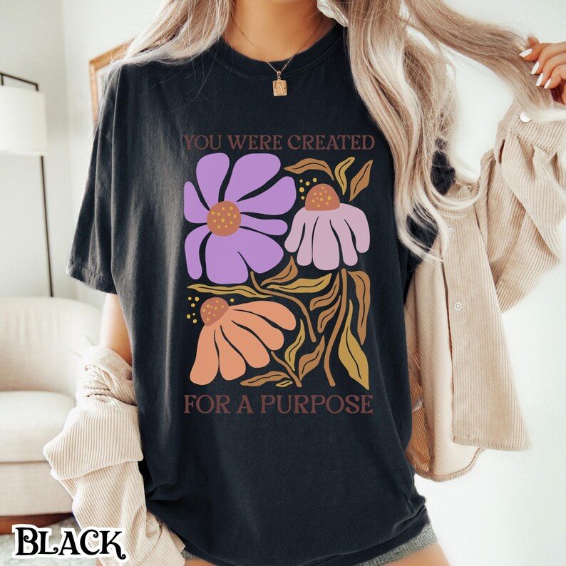 May include: Black t-shirt with a floral design and the text "You were created for a purpose".