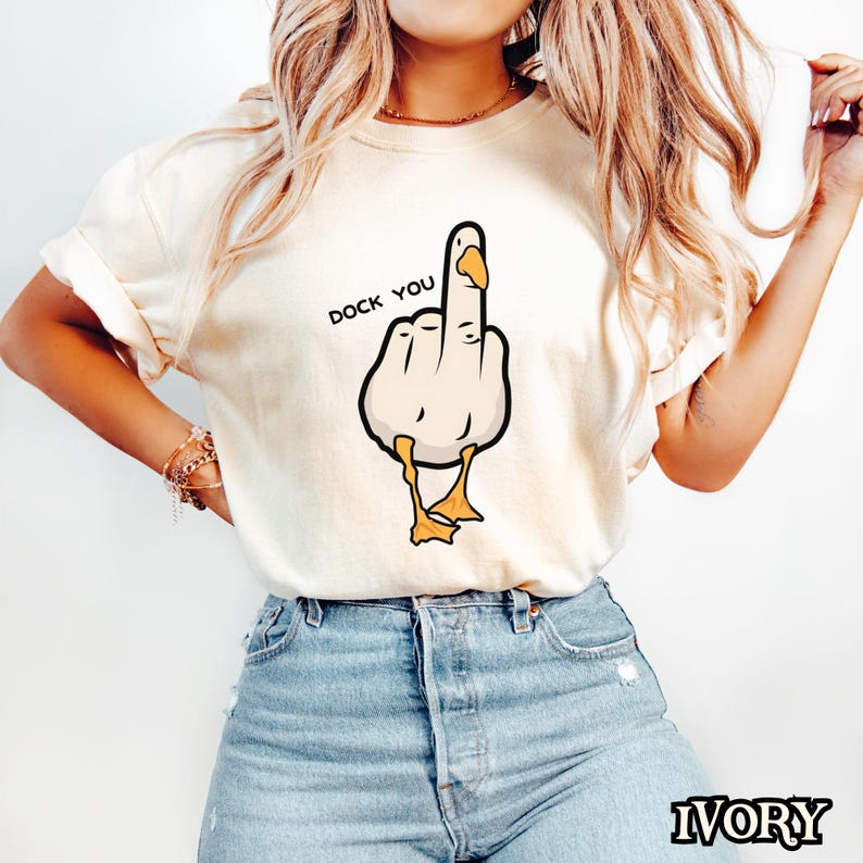 May include: A white t-shirt with a cartoon image of a duck giving the middle finger. The text "DOCK YOU" is printed above the duck.