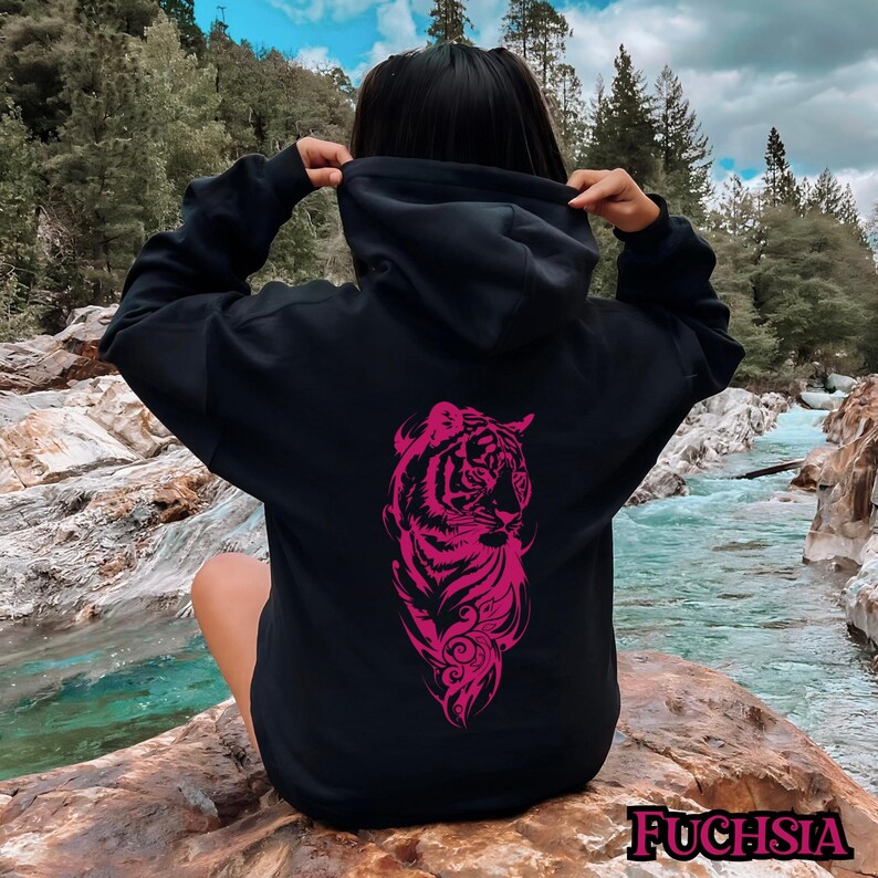 May include: Black hoodie with a pink tiger graphic on the back. The tiger is stylized and has a floral design around it. The hoodie has a drawstring hood.