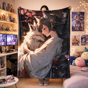 May include: A large, rectangular blanket featuring a digital illustration of a woman with fox ears embracing a white fox. The woman wears a kimono with floral accents. The background is dark with cherry blossoms.