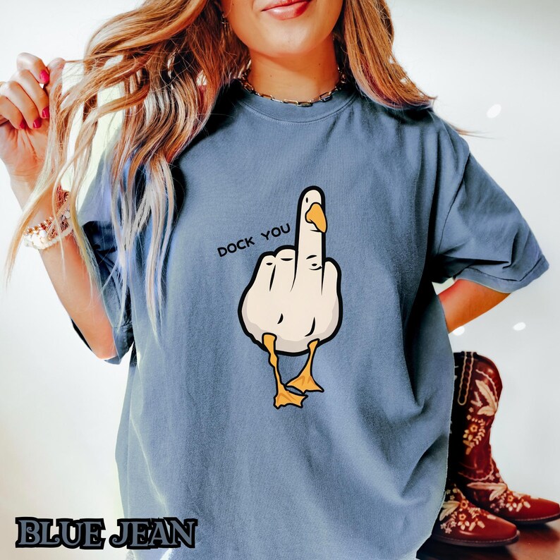 May include: A blue t-shirt with a cartoon goose giving the middle finger and the text "Duck You".