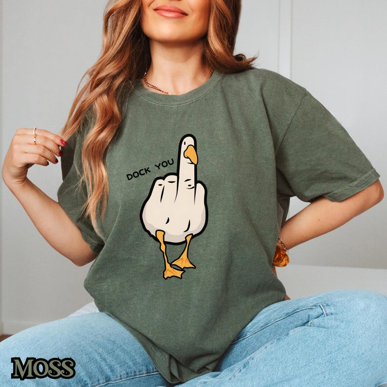 May include: A green t-shirt with a cartoon goose giving the middle finger and the text "Duck You".