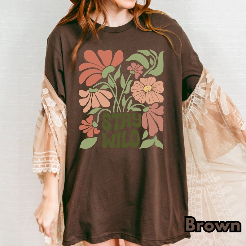 May include: A brown t-shirt with a floral design and the text "Stay Wild" in green.
