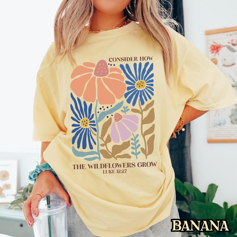May include: Yellow t-shirt with a floral design and the text "Consider How The Wildflowers Grow Luke 12:27"