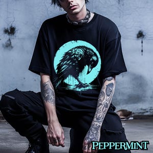 May include: A black t-shirt with a graphic of a black raven in a blue circle. The raven is perched on a branch with its wings spread out.