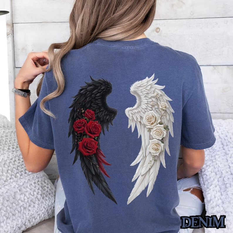 May include: A blue t-shirt with a graphic of black and white angel wings with red roses on the black wing.