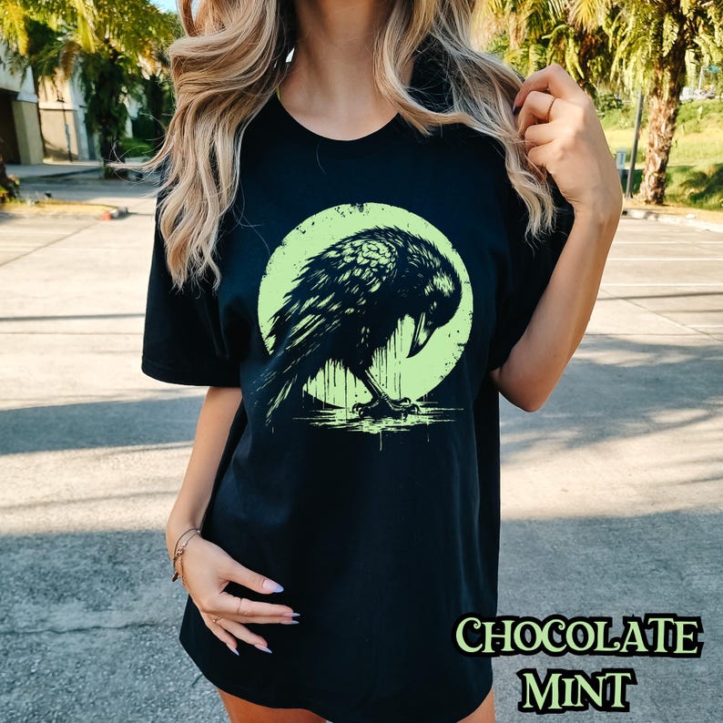May include: Black t-shirt with a graphic of a black raven in front of a green moon. The text "CHOCOLATE MINT" is printed on the bottom of the shirt.