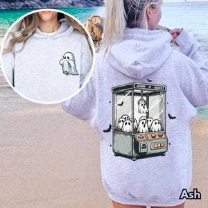 Pode incluir: Um moletom cinza com um gr&aacute;fico de fantasma branco na frente e um gr&aacute;fico de uma m&aacute;quina de garra de fantasmas nas costas. O texto na m&aacute;quina de garra diz "Grab-A-Ghost".