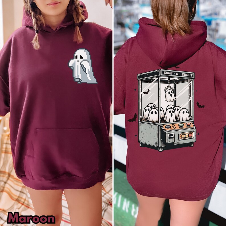 Pode incluir: Um moletom cor vinho com um gr&aacute;fico de fantasma branco na frente e uma m&aacute;quina de garra com fantasmas dentro nas costas. O texto na m&aacute;quina de garra diz "Grab-A-Ghost".