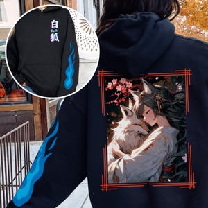 May include: Black hoodie with a blue flame design on the sleeve and a red framed image of a woman with a white fox on the back. The image has Japanese text that says "白狐".