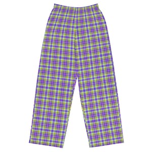 May include: Purple, yellow, and green plaid pajama pants. The pants have a wide-leg design and an elastic waistband. The plaid pattern is a classic design, with intersecting lines creating a grid-like pattern. The pants are made of a soft, comfortable material.