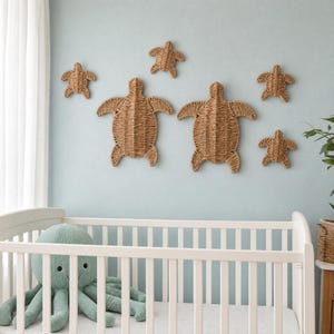 A white crib with a green stuffed octopus toy in a nursery setting, featuring a wall with six woven turtle-shaped wall decorations.