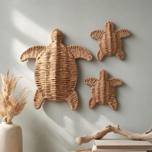 three woven turtle-shaped wall decorations hanging on a light blue wall.