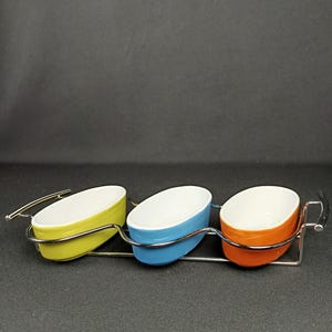 Bols de service colorés style années 60, bols en céramique rétro dans une structure métallique, bols rétro colorés, cuisine de l'ère atomique