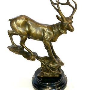 Exclusive bronze statue of a deer in antique style, hunting figure on a marble base, handcrafted bronze sculpture, 1970s luxury decor.