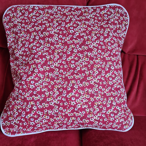 Housse de coussin fleurie avec passepoil blanc