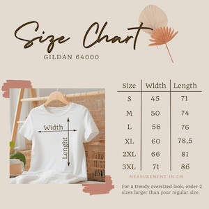 May include: White Gildan 64000 t-shirt on a hanger, with a size chart. The chart shows measurements in centimeters for sizes S to 3XL. The text "Size Chart" is at the top.