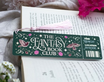 May include: A dark green bookmark with the text "THE FANTASY BOOK CLUB" in white script. The bookmark features bird and rose illustrations, a pink tassel, and the words "TIME MIDNIGHT LOCATION ANYWHERE".