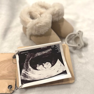 May include: A white ceramic mug with a black handle and the text "But First, Coffee" in a handwritten style. The mug is on a white surface. The mug is approximately 10 cm tall.